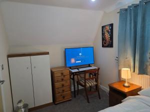 a bedroom with a desk with a computer monitor on it at Guest Room in Colchester Hythe in Hythe