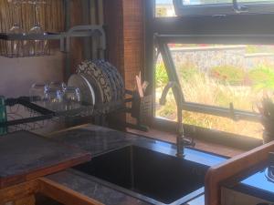 a kitchen counter with a sink and a window at Emelios Lodge Océan View in Port Mathurin