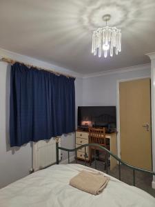 HytheにあるNear Colcheste town centreのベッドとシャンデリアのある寝室