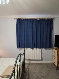 HytheにあるNear Colcheste town centreのベッドルーム(青いカーテン、ベッド1台付)