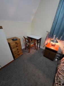 Un dormitorio con un escritorio, una mesa y una cama. en Charming Colchester Room with Garden Views, en Hythe