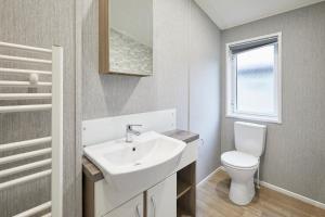 Un baño con lavabo e inodoro en Woodpecker Lodge with Hot Tub, en York 27 fotos más