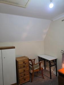 a room with a desk and a chair and a table at Charming Colchester Room with Garden Views in Hythe