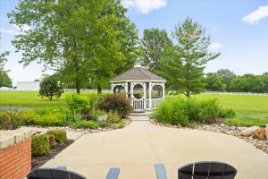 einen Pavillon inmitten eines Gartens in der Unterkunft 2BR Guesthouse Near Lakes with BBQ & Hot Tub in Blue Springs