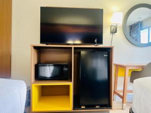 a living room with a tv and a microwave at Days Inn by Wyndham Jellico - Tennessee State Line in Jellico