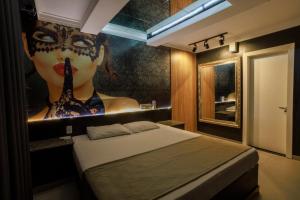 a room with a bed with a picture of a woman at Hotel Motel Paradiso - Carazinho-RS in Caràzinho