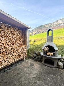 een houtoven naast een stapel hout bij Chalet Bergdoktor in Amden