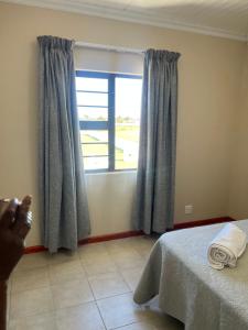 a bedroom with a bed and a large window at 101 Maia in Gqeberha +18 photos