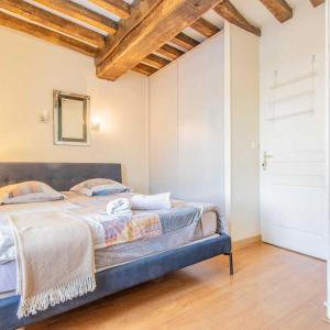 ein Schlafzimmer mit einem Bett in einem Zimmer mit Holzdecke in der Unterkunft Arhomeplus - Gîte & Séjours Bien-être à Autun in Autun