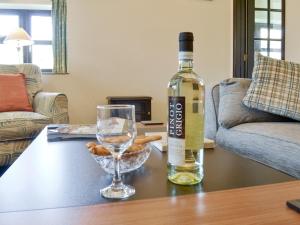 a bottle of wine and a glass on a table at Ramscliff Cottage in Cheddar