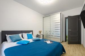a bedroom with a large blue bed with blue pillows at Your Flat Lebedinny in Kyiv