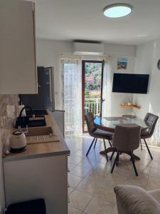 een keuken met een tafel en stoelen in een kamer bij Apartment Seman in Vela Luka
