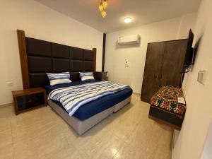 a bedroom with a large bed with a large headboard at Camel Dive Club By The Sea Inn in Aqaba
