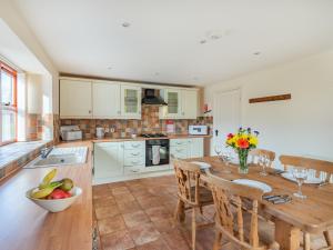 a kitchen with a wooden table with chairs and a dining room at The Parlour - Uk37517 in Routh +12 photos