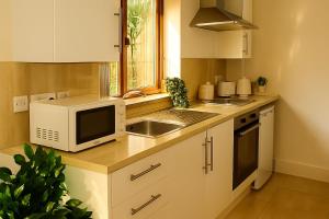 eine Küche mit Mikrowelle und Spüle in der Unterkunft Boutique-Style Studio Near BHX Airport & NEC in Birmingham