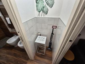 a bathroom with a toilet and a sign on the wall at Maison Alice in Alba