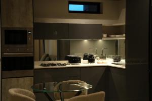 ヨハネスブルグにあるSecure and modern private flat Houghton Estateのキッチン(コンロ、ガラスのテーブル付)