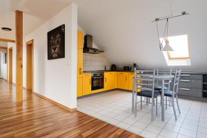 a kitchen with yellow cabinets and a table and chairs at Moritz Apartments - Dosborn 7 in Dingelstädt