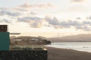 リベイラ・グランデにあるMoinho da Areiaのビーチと海の景色を望めます。