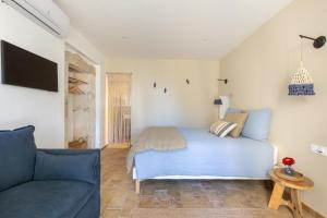 a bedroom with a blue bed and a couch at Terres Élaïs in Robion en Luberon