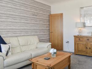 a living room with a white couch and a coffee table at Berwick Lodge in Thornton
