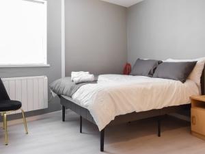 a bedroom with a bed with a chair and a window at Apartment 2 - Uk50136 in Stoke on Trent