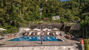 a woman is standing in front of a swimming pool at Hotel Mystic Mountain, Pokhara in Pokhara