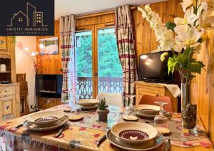 a dining room table with plates and dishes on it at Chaleureux 2 chambres, Morillon in Morillon