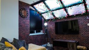 un salon avec un mur de briques et une télévision dans l'établissement Stunning Two Bed City Centre Apartment, à Hunslet