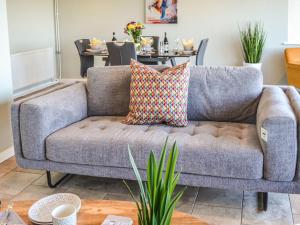ein graues Sofa im Wohnzimmer mit einem Tisch in der Unterkunft Sunrise Beach in Scratby