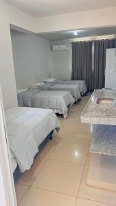 a row of beds in a room with a sink at Hotel Panorama Palace in Janaúba