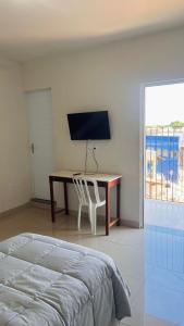 a bedroom with a desk with a computer and a bed at Hotel Panorama Palace in Janaúba