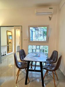 a dining room with a wooden table and chairs at Cozy apartment with private patio in Lomé