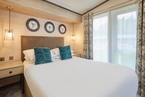 ein Schlafzimmer mit einem großen Bett und Uhren an der Wand in der Unterkunft Teejay's Lodge with Hot Tub in York