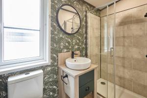 ein Badezimmer mit Waschbecken und Spiegel in der Unterkunft Teejay's Lodge with Hot Tub in York + 27 Fotos