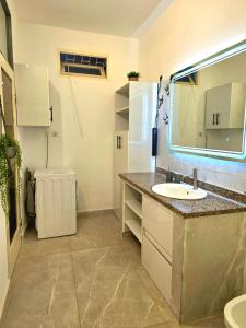 a bathroom with a sink and a mirror at Cozy apartment with private patio in Lomé +9 photos