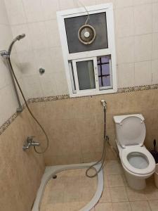 a bathroom with a toilet and a window and a shower at Kourosh in Muscat