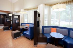 een wachtkamer met blauwe stoelen en tafels bij Courtyard Sacramento Airport Natomas in Sacramento