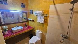 ein Badezimmer mit Toilette, Waschbecken und Spiegel in der Unterkunft Maridadi Plaza Apartment in Jambiani + 19 Fotos