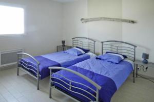 two beds in a room with blue sheets at Modern semi-detached house with terrace, Saint-Quay-Portrieux in Saint-Quay-Portrieux