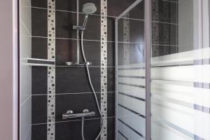 a shower with a shower head in a bathroom at Modern semi-detached house with terrace, Saint-Quay-Portrieux in Saint-Quay-Portrieux +49 photos