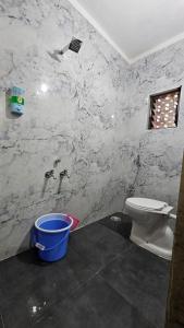 een badkamer met een toilet en een emmer bij Hotel Sai Pratham in Shirdi