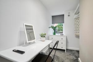 a white office with a desk with a computer on it at Luxury Lower-Level Two Bed Apt in Headingley +15 photos
