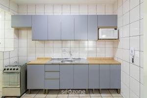a kitchen with a sink and a microwave at Aptos completos em Meia Praia a 150m do Mar - EOOs in Meia Praia