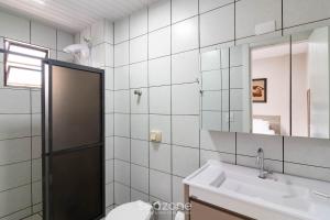 a bathroom with a sink and a toilet and a mirror at Aptos completos em Meia Praia a 150m do Mar - EOOs in Meia Praia +26 photos