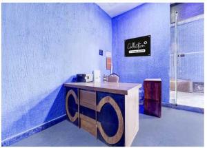 a blue room with a desk with a sign on the wall at Collection O Mappedu Chennai Formerly Nitas Business Hotel in Kāndūr