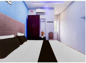 a bedroom with a large bed and a red cabinet at Collection O Mappedu Chennai Formerly Nitas Business Hotel in Kāndūr +9 photos