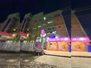 um edifício com um sinal rosa na lateral em Hotel O Shakuntala Park Bus Terminus Behala em Behāla