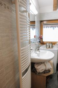 un bagno con lavandino, WC e specchio di Luggishof a Campo Tures Altre 35 foto