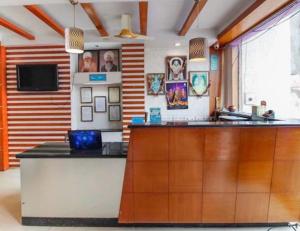 a kitchen with a bar with a tv on the wall at Hotel O Vemulawada Temple Formerly Kamakshi Bliss in Vemalwāda